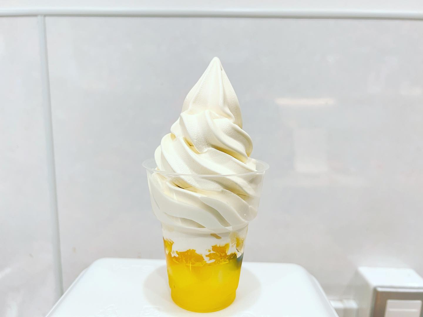 『フルーツレモンゼリー
北海道ソフトクリーム』
レモンゼリーの中にはハウスみかんやブルーベリーなどのフルーツのほかナタデココも隠れています。これが食べすすんでいくと凄くいいアクセントになってきます。苺、ブドウ、レモンのトッピングの上にとろ〜リ蜂蜜がかけられています。このレモンゼリーに北海道ソフトクリームを盛れば完成です。